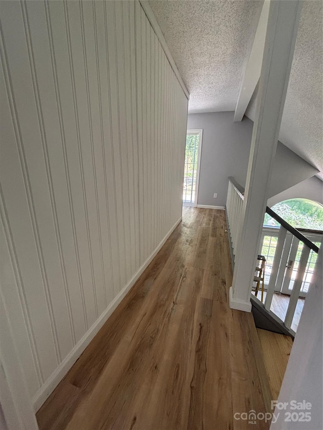 39 Moondust Dr, Waynesville, NC 28786 - hallway with a textured ceiling, wood finished floors, an upstairs landing, and vaulted ceiling