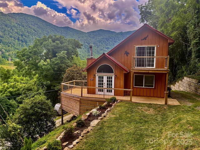39 Moondust Dr, Waynesville, NC 28786 - view of front facade featuring french doors, a chimney, board and batten siding, and a deck with mountain view