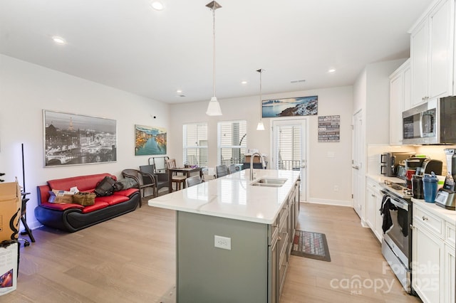 334 Chattooga Way, Charlotte, NC 28211 - kitchen with stainless steel appliances, light wood finished floors, a center island with sink, white cabinetry, and recessed lighting