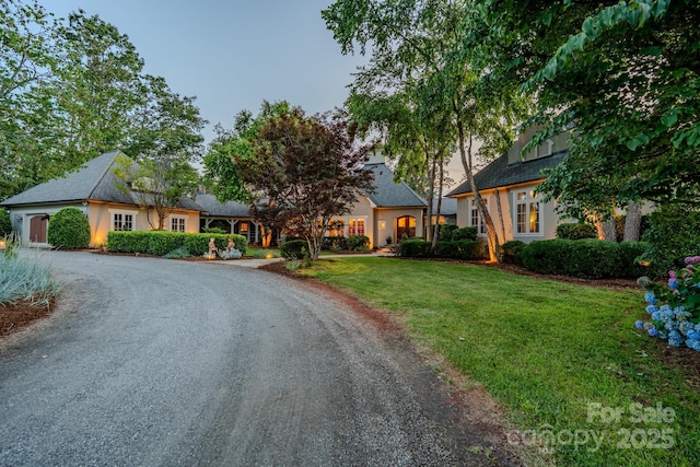 650 Golf Course Rd, Columbus, NC 28722 - view of front of house with curved driveway, a front yard, and stucco siding