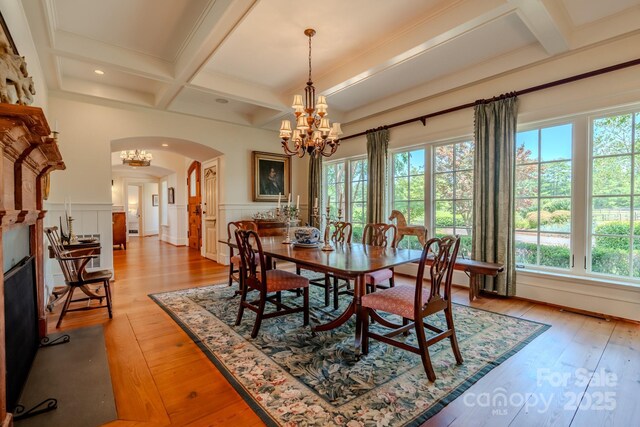 650 Golf Course Rd, Columbus, NC 28722 - dining space featuring coffered ceiling, a chandelier, arched walkways, beamed ceiling, and wainscoting
