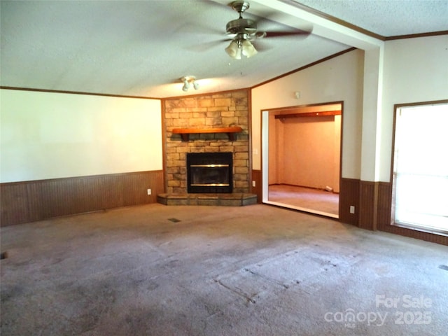 113 Dillon St, Winston Salem, NC 27107 - unfurnished living room featuring vaulted ceiling, ornamental molding, wainscoting, a stone fireplace, and carpet floors