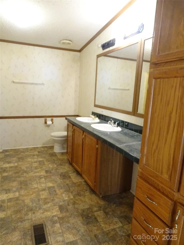 113 Dillon St, Winston Salem, NC 27107 - bathroom featuring crown molding, double vanity, and wallpapered walls