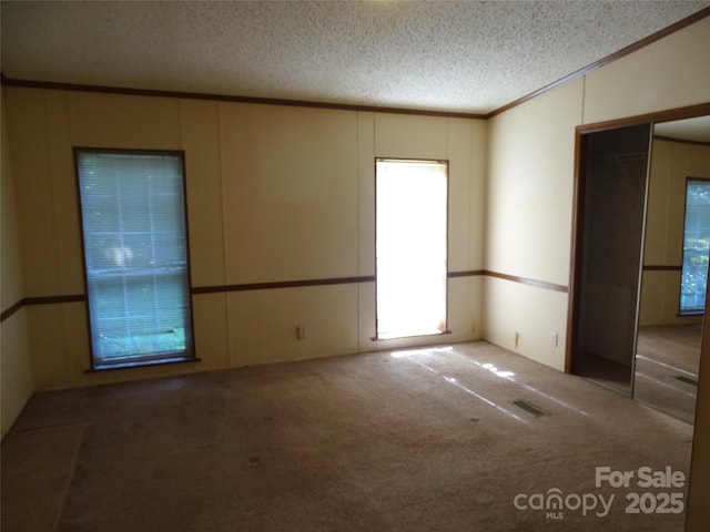 113 Dillon St, Winston Salem, NC 27107 - carpeted empty room with a textured ceiling, ornamental molding, and a decorative wall