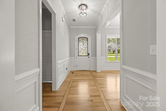 4930 Killian Crossing Dr, Denver, NC 28037 - doorway with crown molding, a decorative wall, wainscoting, and light wood-style flooring