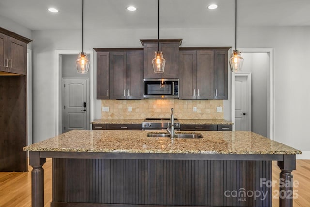 4930 Killian Crossing Dr, Denver, NC 28037 - kitchen featuring appliances with stainless steel finishes, dark brown cabinetry, light wood finished floors, tasteful backsplash, and recessed lighting