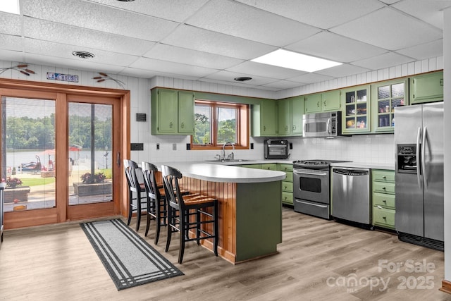 643 Lake Dr Unit 10, Lexington, NC 27292 - kitchen featuring green cabinetry, stainless steel appliances, a peninsula, a breakfast bar, and a paneled ceiling