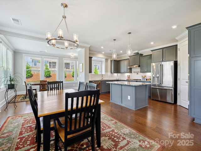 10305 Superb Ln, Charlotte, NC 28215 - dining area with healthy amount of natural light, ornamental molding, a chandelier, dark wood finished floors, and recessed lighting