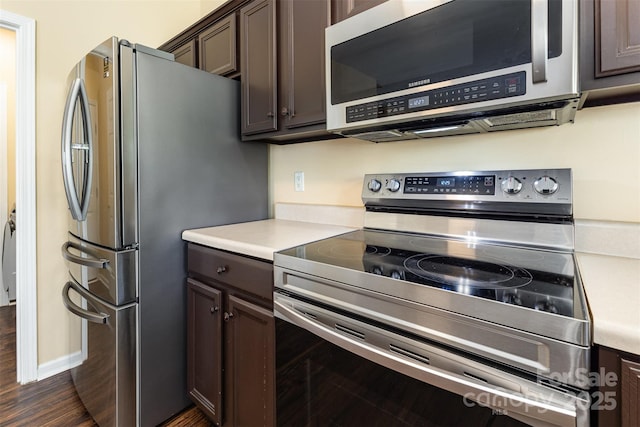 4208 Carl Parmer Dr, Harrisburg, NC 28075 - kitchen featuring appliances with stainless steel finishes, dark brown cabinets, light countertops, and dark wood-type flooring