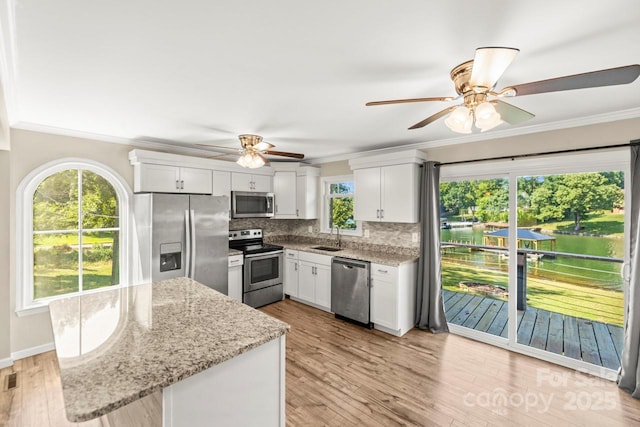 172 Honeydew Cir, Troutman, NC 28166 - kitchen featuring stainless steel appliances, a ceiling fan, crown molding, backsplash, and white cabinets