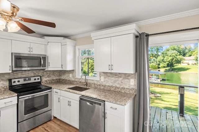 172 Honeydew Cir, Troutman, NC 28166 - kitchen with stainless steel appliances, crown molding, white cabinets, backsplash, and ceiling fan