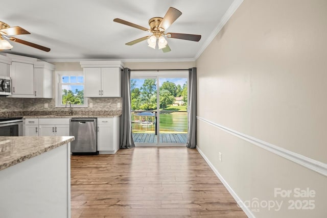172 Honeydew Cir, Troutman, NC 28166 - kitchen featuring stainless steel appliances, ceiling fan, white cabinetry, ornamental molding, and backsplash