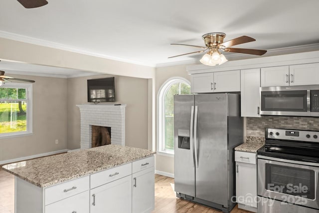 172 Honeydew Cir, Troutman, NC 28166 - kitchen with stainless steel appliances, a ceiling fan, plenty of natural light, and ornamental molding