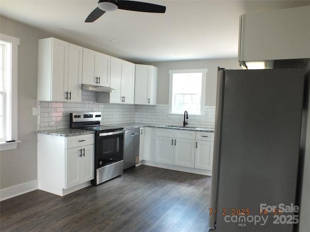 1732 Rocky River Rd, Lancaster, SC 29720 - kitchen with appliances with stainless steel finishes, under cabinet range hood, backsplash, ceiling fan, and white cabinetry