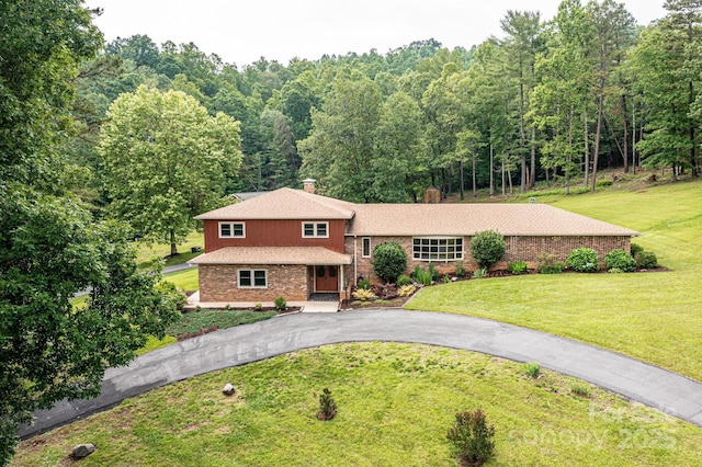 221 Roberts Ln, Lenoir, NC 28645 - tri-level home featuring brick siding, a front lawn, asphalt driveway, and a wooded view