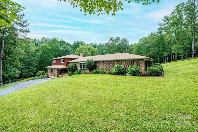 221 Roberts Ln, Lenoir, NC 28645 - tri-level home featuring a chimney, a front lawn, driveway, and a view of trees