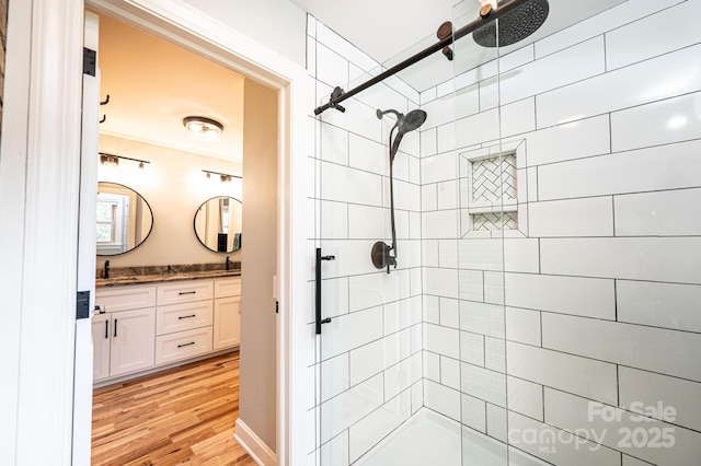 221 Roberts Ln, Lenoir, NC 28645 - bathroom with a tile shower, double vanity, and wood finished floors