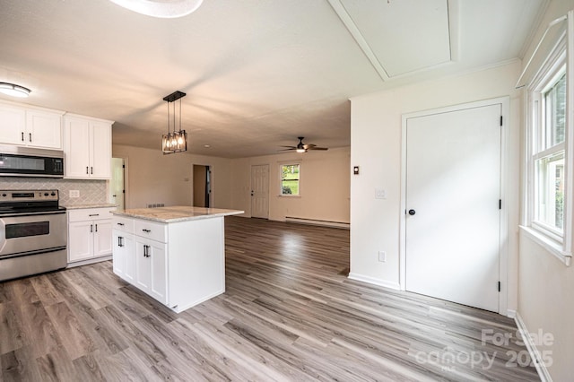 221 Roberts Ln, Lenoir, NC 28645 - kitchen with stainless steel range with electric cooktop, black microwave, decorative backsplash, light wood-type flooring, and white cabinetry