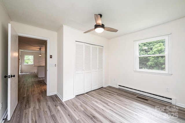 221 Roberts Ln, Lenoir, NC 28645 - unfurnished bedroom featuring baseboard heating, light wood finished floors, a closet, ornamental molding, and ceiling fan