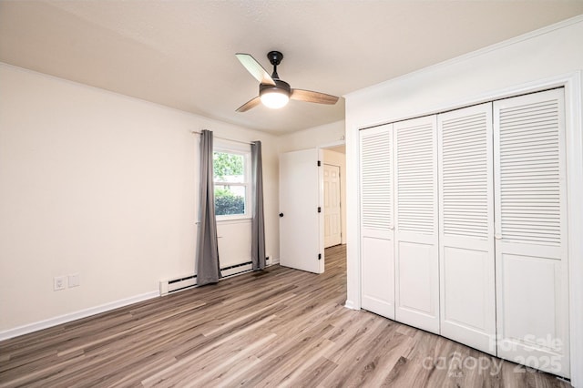 221 Roberts Ln, Lenoir, NC 28645 - unfurnished bedroom featuring light wood-style flooring, a closet, a ceiling fan, and a baseboard radiator