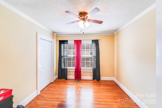 1004 Venus St, Kannapolis, NC 28083 - empty room with light wood finished floors, a textured ceiling, ceiling fan, and crown molding