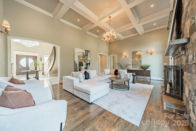 802 Capington Ln, Waxhaw, NC 28173 - living room featuring a chandelier, arched walkways, a fireplace, a high ceiling, and beamed ceiling