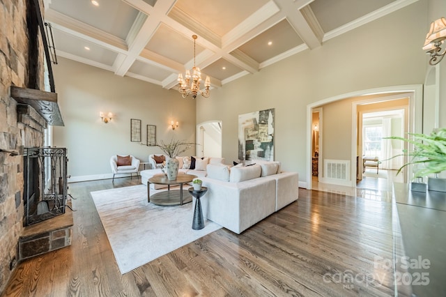 802 Capington Ln, Waxhaw, NC 28173 - living room with arched walkways, a towering ceiling, a fireplace, beamed ceiling, and wood finished floors