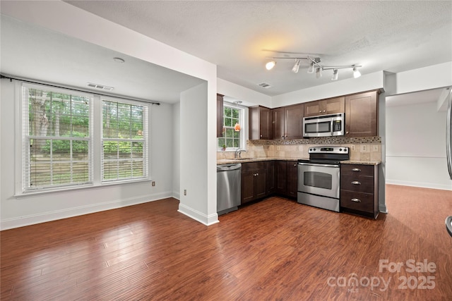 1230 Ridgebury Ter, Matthews, NC 28105 - kitchen featuring appliances with stainless steel finishes, dark brown cabinets, decorative backsplash, dark wood-type flooring, and a textured ceiling