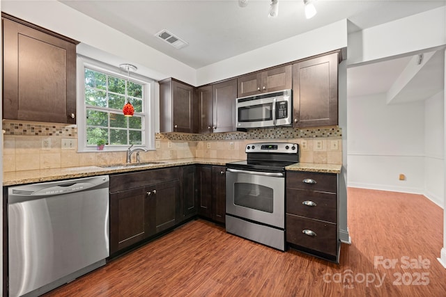 1230 Ridgebury Ter, Matthews, NC 28105 - kitchen with stainless steel appliances, dark brown cabinets, wood finished floors, and light stone countertops