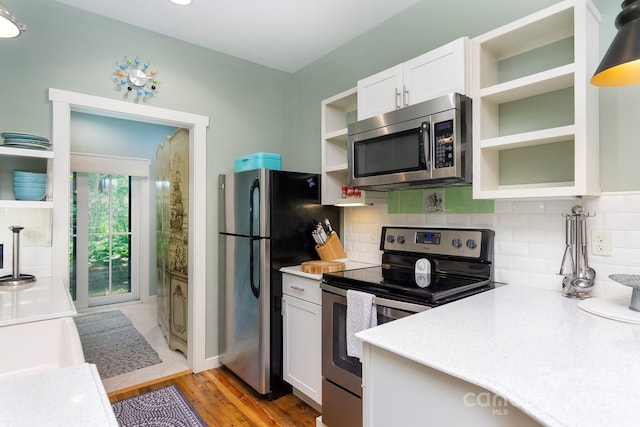 611 Hiawassee Rd, Black Mountain, NC 28711 - kitchen with stainless steel appliances, open shelves, white cabinets, and tasteful backsplash