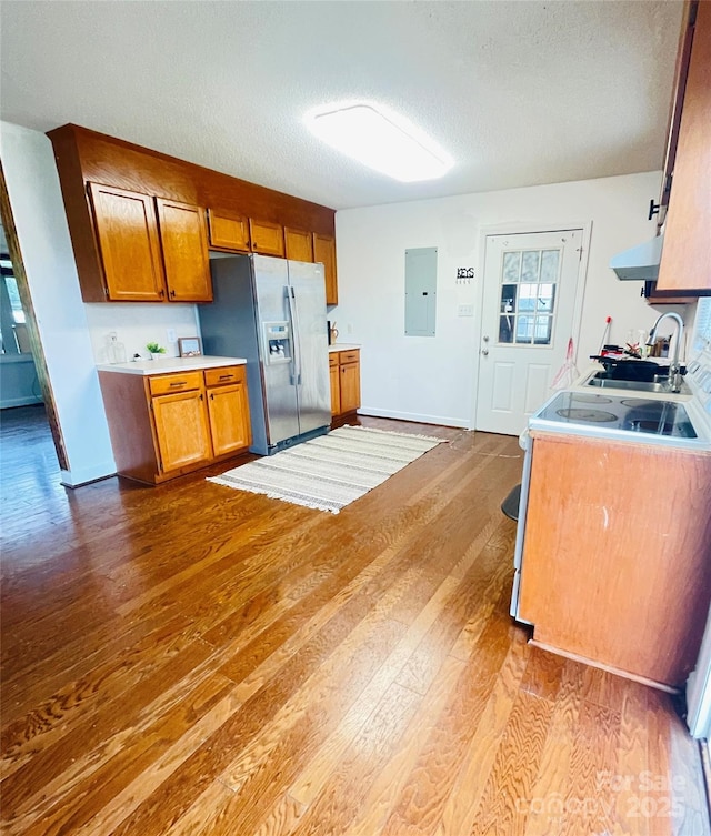 286 Little Wilkesboro Rd, Harmony, NC 28634 - kitchen featuring stainless steel refrigerator with ice dispenser, electric panel, brown cabinetry, a textured ceiling, and wood finished floors