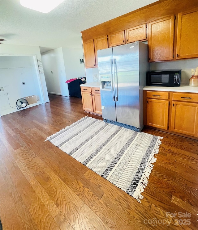 286 Little Wilkesboro Rd, Harmony, NC 28634 - kitchen with stainless steel fridge with ice dispenser, black microwave, dark wood finished floors, light countertops, and brown cabinets