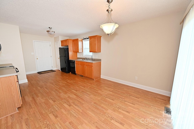 202 Pine Meadows St, Hickory, NC 28601 - kitchen featuring black appliances, light countertops, light wood finished floors, a textured ceiling, and hanging light fixtures