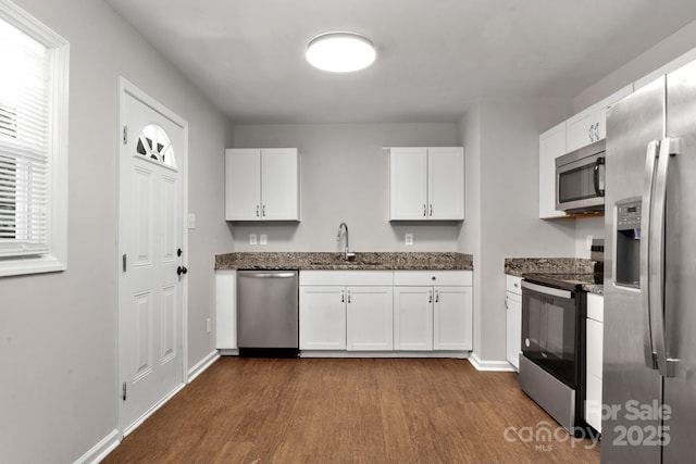 6101 Mcgregor Dr, Charlotte, NC 28227 - kitchen with stainless steel appliances, dark wood-style flooring, white cabinetry, and dark stone countertops