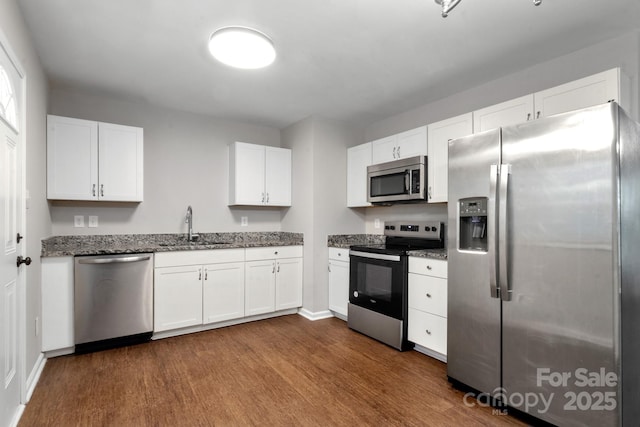 6101 Mcgregor Dr, Charlotte, NC 28227 - kitchen with appliances with stainless steel finishes, dark wood-style flooring, white cabinetry, and dark stone counters