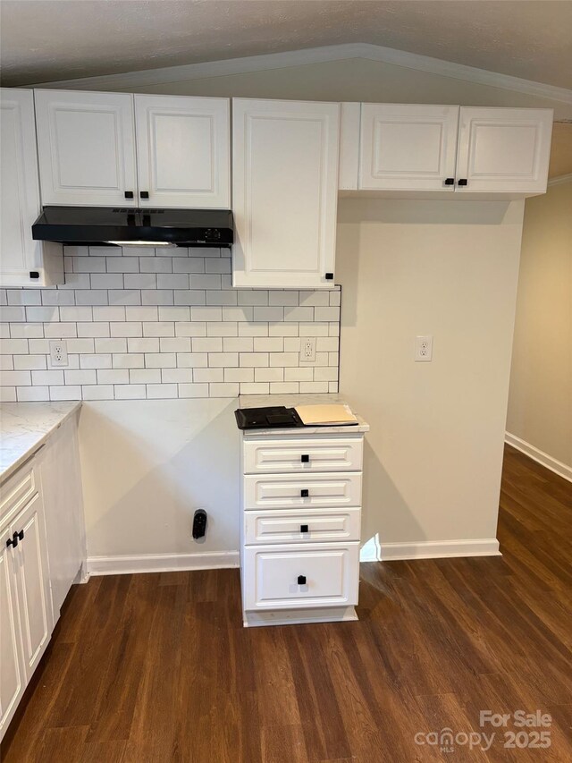 114 Woodberry Dr, Cherryville, NC 28021 - kitchen with under cabinet range hood, dark wood-style floors, white cabinets, tasteful backsplash, and lofted ceiling