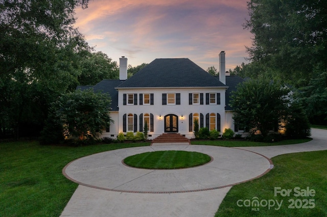 533 Valley Run Dr, Waxhaw, NC 28173 - colonial home featuring french doors, curved driveway, a chimney, a lawn, and stucco siding