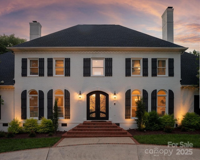 533 Valley Run Dr, Waxhaw, NC 28173 - georgian-style home featuring french doors, brick siding, a chimney, and a shingled roof