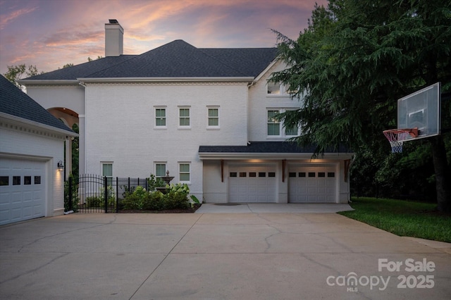 533 Valley Run Dr, Waxhaw, NC 28173 - rear view of property featuring driveway, a chimney, brick siding, and a garage