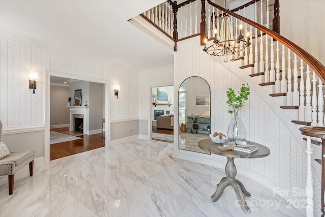 533 Valley Run Dr, Waxhaw, NC 28173 - entryway featuring wallpapered walls, stairs, a fireplace, ornamental molding, and a chandelier
