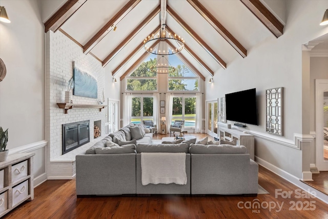 533 Valley Run Dr, Waxhaw, NC 28173 - living area featuring high vaulted ceiling, a chandelier, a fireplace, beamed ceiling, and dark wood-type flooring