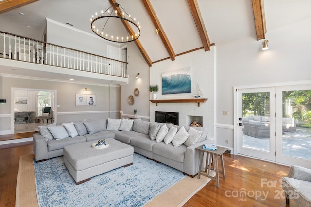 533 Valley Run Dr, Waxhaw, NC 28173 - living room featuring high vaulted ceiling, wood finished floors, a chandelier, beamed ceiling, and a brick fireplace