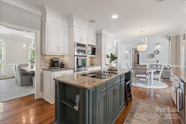 533 Valley Run Dr, Waxhaw, NC 28173 - kitchen with black electric stovetop, stainless steel double oven, a chandelier, white cabinetry, and crown molding
