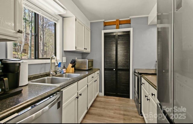26 Pinetop Cir Unit B, Banner Elk, NC 28604 - kitchen featuring stainless steel appliances, dark countertops, light wood finished floors, and white cabinets