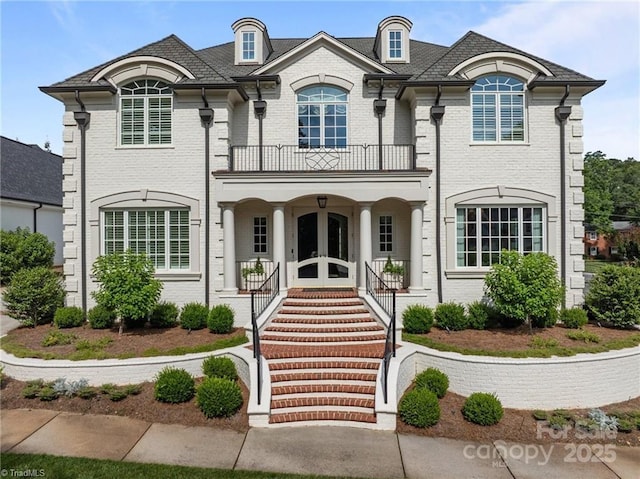 2990 Reynolds Sq, Winston Salem, NC 27106 - french country style house with a balcony, a porch, brick siding, and french doors
