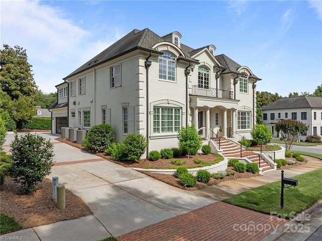 2990 Reynolds Sq, Winston Salem, NC 27106 - view of front of house featuring a balcony, brick siding, and driveway