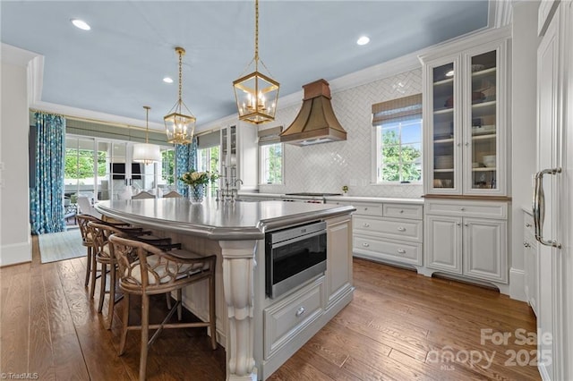2990 Reynolds Sq, Winston Salem, NC 27106 - kitchen featuring crown molding, a chandelier, a kitchen bar, a kitchen island with sink, and hardwood / wood-style flooring