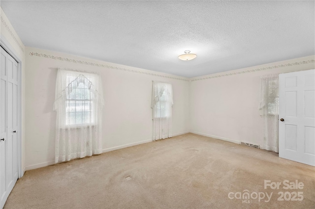 218 Rose St, Mount Holly, NC 28120 - unfurnished bedroom featuring carpet flooring, a closet, and a textured ceiling