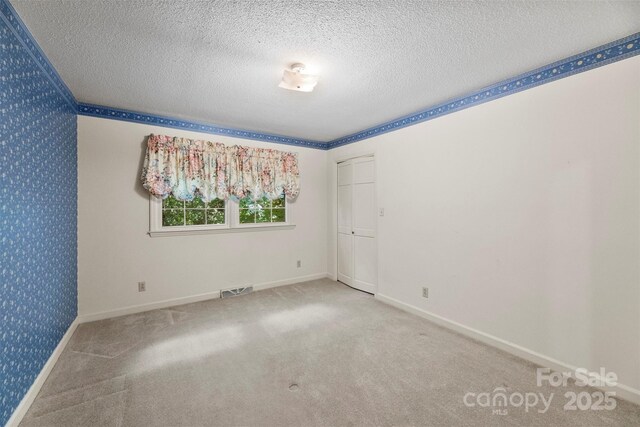 218 Rose St, Mount Holly, NC 28120 - empty room featuring a textured ceiling, carpet floors, and wallpapered walls