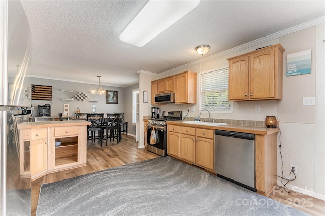 108 W Welsh St, Kershaw, SC 29067 - kitchen with stainless steel appliances, light wood-style floors, ornamental molding, a textured ceiling, and light brown cabinetry